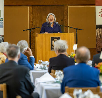 View from the audience of the Governor General speaking from a podium.