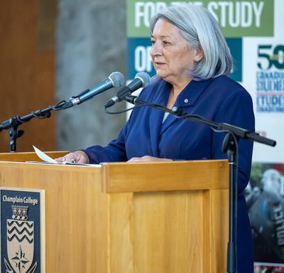 Side angle of the Governor General speaking at a podium.