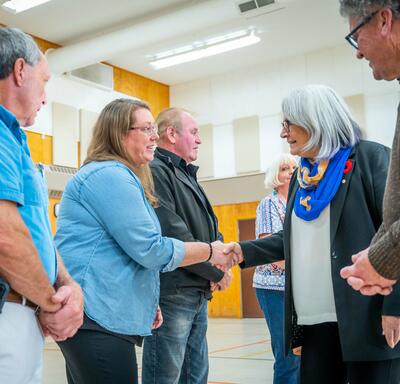 The Governor General is shaking hands with volunteers and community members.