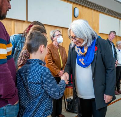 The Governor General is shaking hands with volunteers and community members.