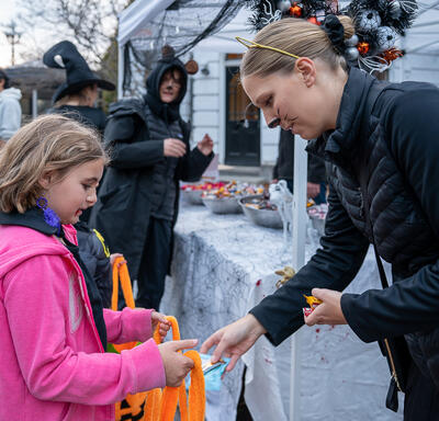 A young child is receiving Halloween treats.