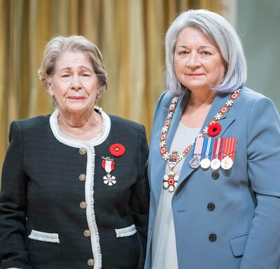 Berna Valencia Garron is standing next to the Governor General.