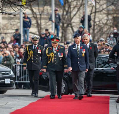 The Governor General is walking on a red carpet towards the National War Memorial. She is wearing the Canadian Army uniform.