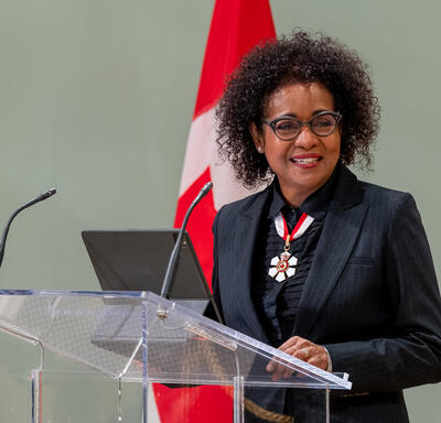 The Right Honourable Michaëlle Jean is standing at a podium in the ballroom at Rideau Hall.