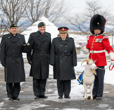 La gouverneure générale se tient aux côtés de membres de l'armée, d'une garde de cérémonie et d'une chèvre.