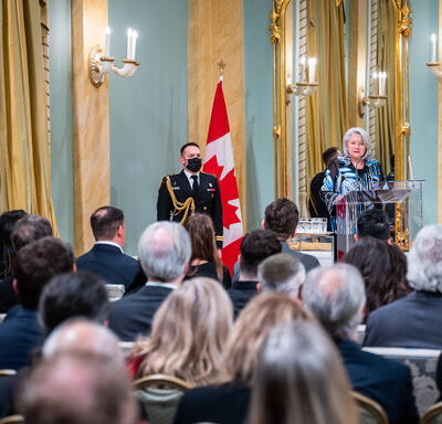 Governor General Simon is addressing a crowd in the Ballroom at Rideau Hall.