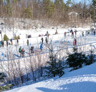 A group of ice skaters on an outdoor rink.