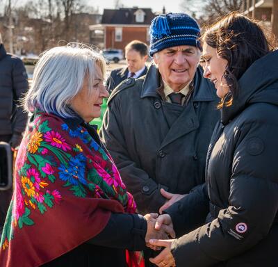 Governor General Simon shaking a woman’s hand. Mr. Fraser is standing behind them.