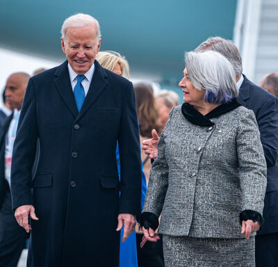 Governor General Simon walks next to U.S President Joe Biden. There is a group of people behind them.