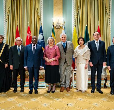 A group photo featuring Governor General Simon and six new heads of mission. Behind them are the flags of each country.