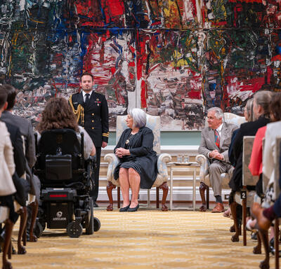 La gouverneure générale Marie Simon est assise sur une chaise pendant la cérémonie