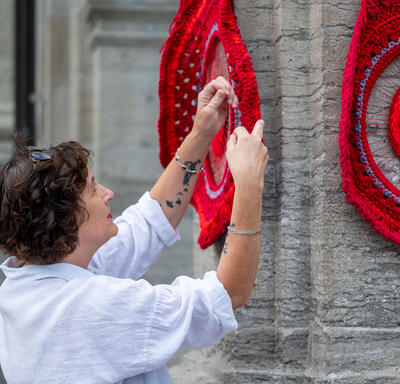 Métis artist Tracey-Mae Chambers hangs her artwork on the porte-cochère of Rideau Hall