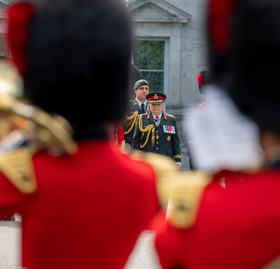 Governor General Mary Simon is seen between two musicians of the Ceremonial Guard. She is wearing a Canadian Armed Forces army uniform.