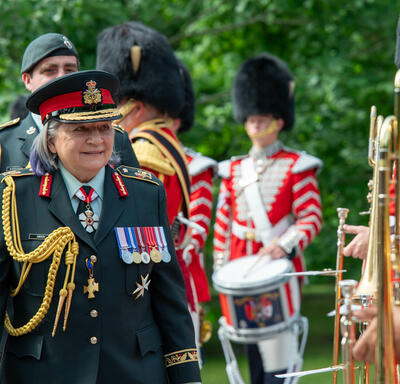 La gouverneure générale Marie Simon inspecte la Garde de cérémonie. Elle porte un uniforme de l'armée des Forces armées canadiennes.