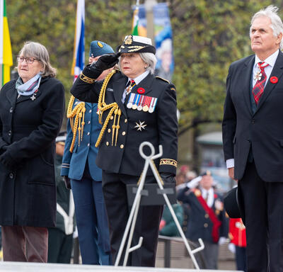 Governor General Mary Simon, accompanied by Mr. Whit Fraser, salutes