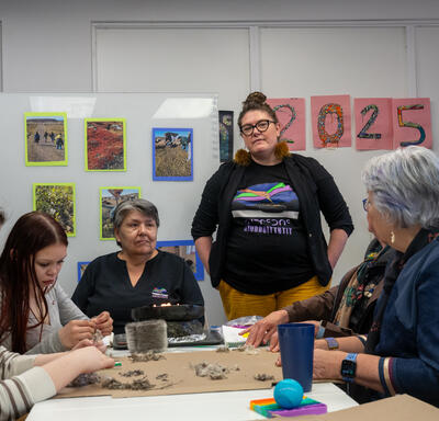 La gouverneure générale Mary Simon discute avec un groupe de personnes au Centre de ressources Piruqatigiit.