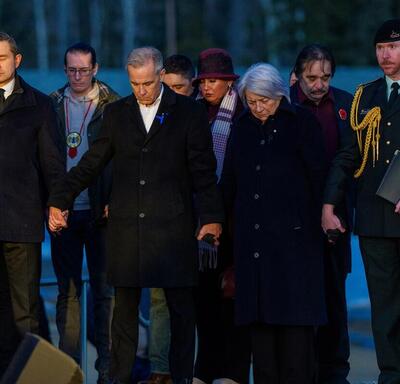 Governor General Mary Simon, Prime Minister of Canada Mark Carney, and Leader of the Official Opposition Party of Canada Pierre Poilievre, standing hand in hand. There are individuals standing behind them.