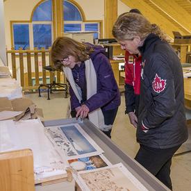 Son Excellence qui contemple les impressions de paysages de l'Arctique canadien dessiné par des artistes locaux.