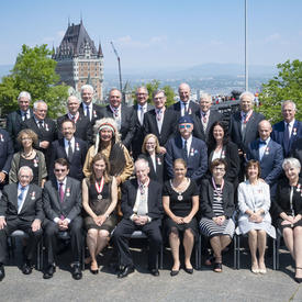 Newly invested members of the Order of Canada take a group photo with the Governor General.