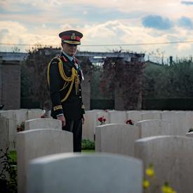 The Governor General walks through a cemetery. 