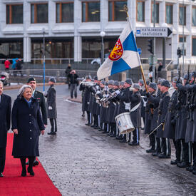 Governor General Simon and President Sauli Niinistö walking down a red carpet. They are inspecting a guard of honour.
