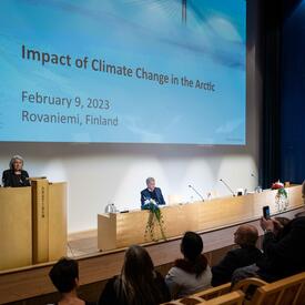 La gouverneure générale Mary Simon est debout sur une scène et parle au microphone. Elle s’adresse à une foule de personnes assises devant elle.