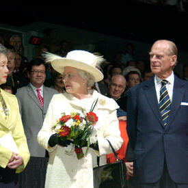 John Ralston Saul, Governor General Clarkson, The Queen and the Duke of Edinburgh stand facing each other, as guests look on from the background.