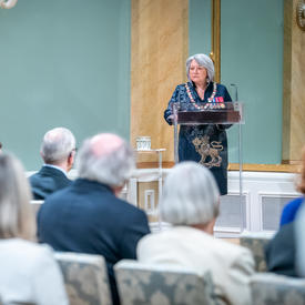 The Governor General is standing at a podium in the ballroom at Rideau Hall.
