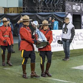 Members of the RCMP carried the Grey Cup onto the field.