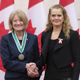 Rina Arseneault is posing for a picture with the Governor General. 