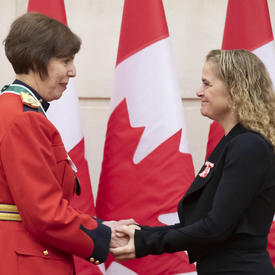 Shirley Cuillierrier is shaking hands with the Governor General. 