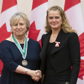 Rina Fraticelli is posing for a picture with the Governor General. 