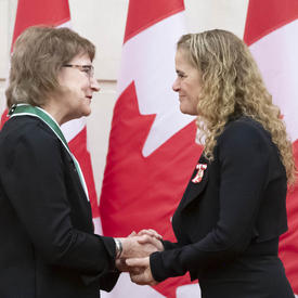 Charlotte Hrenchuk is shaking hands with the Governor General. 