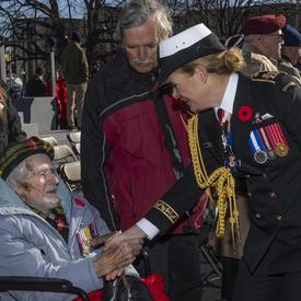 The Governor General shakes the hand of a veteran in a wheelchair. 