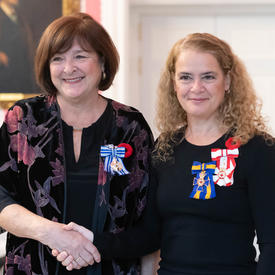 The Governor General stands next to recipient Rachel Corneille Gravel who is wearing the Meritorious Service Medal (Civil Division) she has just received. 