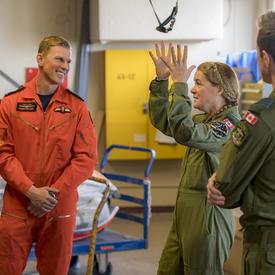 Dressed in her flight suit, the Governor General is talking to members of the 435 Squadron.