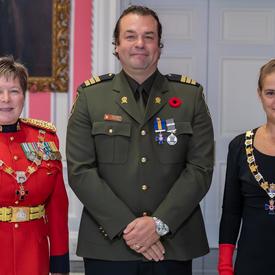 The Governor General and the Commissioner of the RCMP take a photo with a recipient of the Order of Merit of the Police Forces.