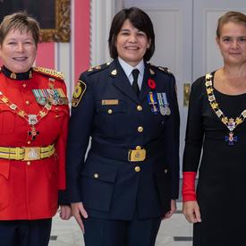 La gouverneure générale et le commissaire de la GRC prennent une photo avec un récipiendaire de l'Ordre du mérite des corps policiers.