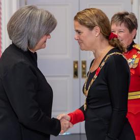 The Governor General shakes hands with a recipient of the Order of Merit of the Police Forces.