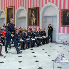 Un récipiendaire de l'Ordre du mérite des corps policiers se dirige vers l'avant de la salle de tente pour recevoir sa médaille.