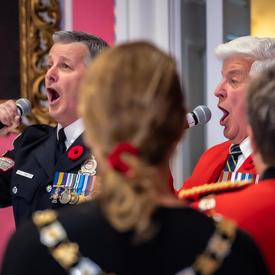 L'hymne national est chanté par deux chanteurs alors que le public se tient debout en solidarité.