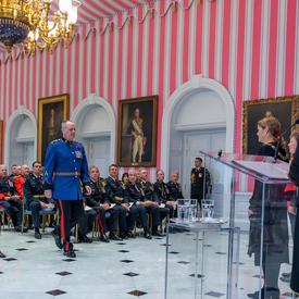 A recipient of the Order of Merit of the Police Forces walks to the front of the tent room to accept his medal.