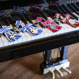 Une série de médailles sont placées sur le clavier d'un piano. 