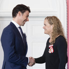 Alex Harvey faces the Governor General and shakes her hand. 