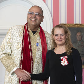 Amar (Alex) Sangha shakes the Governor General's hand and poses for a photo. 