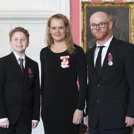Cameron Gouck and Keegan Herries pose for a photo with he Governor General. They stand side by side looking directly at the camera.  