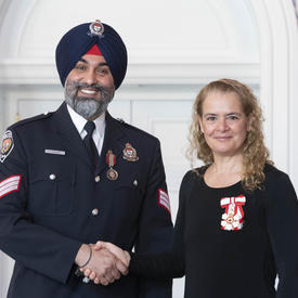 Jasdeep Bajwa shakes the Governor General's hand and poses for a photograph. 