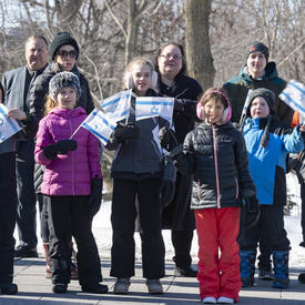 Des membres de la communauté juive brandissent des drapeaux israéliens à l'extérieur. 