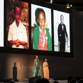 Pictures of children are displayed on a screen on the stage.