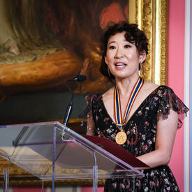 Sandra Oh delivers remarks from the podium. 